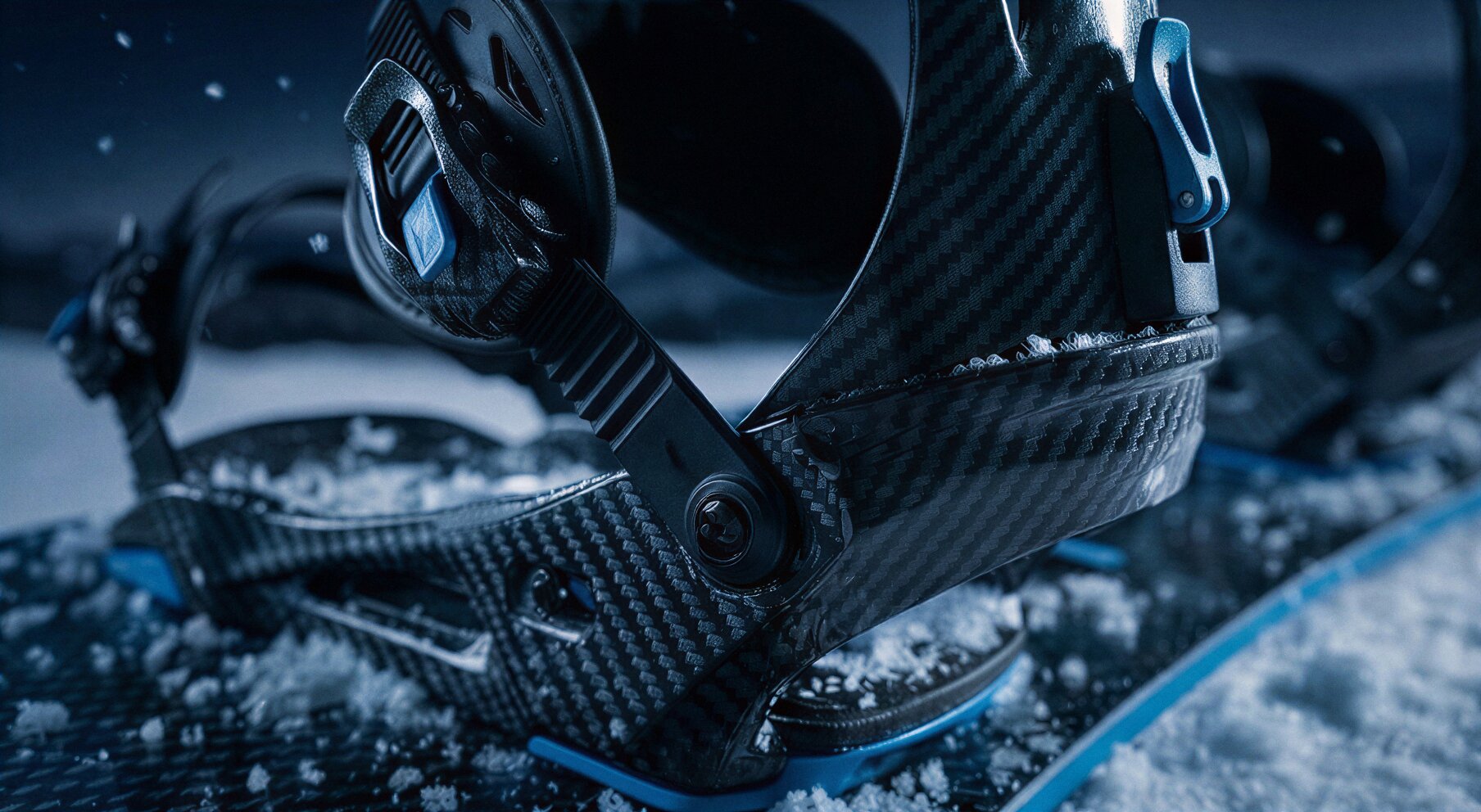 Close-up of carbon fiber binding details on the snowboard.